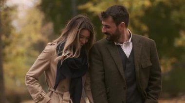 Güz parkında yürüyen yakışıklı genç çift.