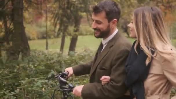 Schönes junges Paar im Herbstpark mit Elektrofahrrad