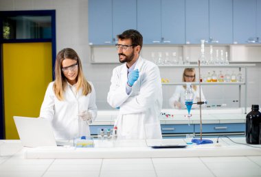 Araştırmacılar laboratuvardaki ayrıştırıcı hunide mavi sıvıyla çalışıyorlar.