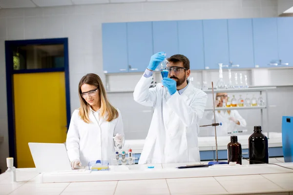 Knappe Jonge Onderzoeker Werkt Met Blauwe Vloeistof Laboratoriumglas Het Lab — Stockfoto