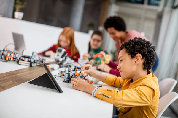 Grupa Szczęśliwych Dzieci Swoją Afroamerykańską Nauczycielką Fizyki Laptopem Programującą Zabawki — Zdjęcie stockowe