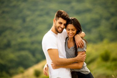 Bir yaz günü çim tarlasında aşık mutlu genç bir çift