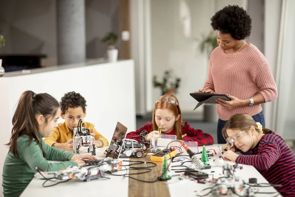 Gruppe Glücklicher Kinder Mit Ihrer Afroamerikanischen Naturwissenschaftlerin Mit Laptop Programmierung — Stockfoto