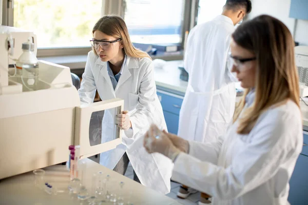 Молоді Жінки Вчені Білій Лабораторії Кладуть Флакон Зразком Аналізу Іоннохроматографічній — стокове фото