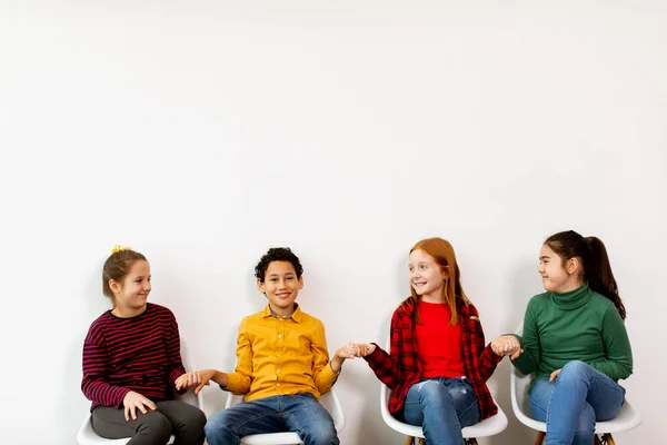 Retrato Lindos Niños Pequeños Jeans Sentados Sillas Contra Pared Blanca —  Fotos de Stock