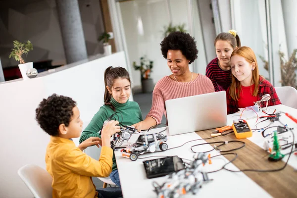 Gruppe Glücklicher Kinder Mit Ihrer Afroamerikanischen Naturwissenschaftlerin Mit Laptop Programmierung — Stockfoto