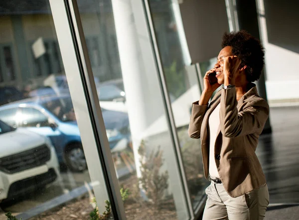 Afroamerikansk Affärskvinna Med Mobiltelefon Vid Fönstret Kontoret Solig Dag — Stockfoto