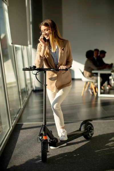 Jolie Jeune Femme Debout Près Fenêtre Bureau Avec Scooter Électrique — Photo