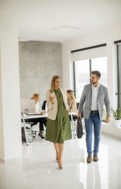 Ofiste birlikte yürüyen yakışıklı genç bir çift.