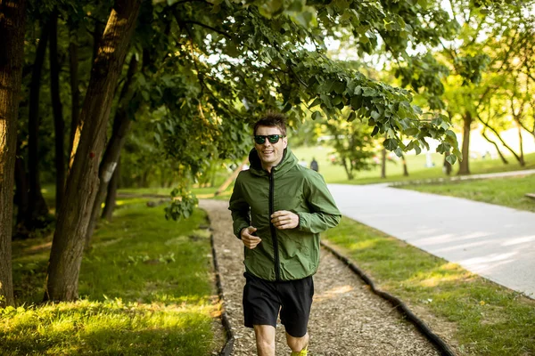 Güneşli Yeşil Parkta Spor Yaparken Koşan Yakışıklı Genç Adam — Stok fotoğraf