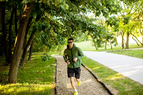 Güneşli Yeşil Parkta Spor Yaparken Koşan Yakışıklı Genç Adam — Stok fotoğraf