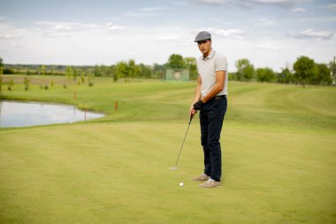 Golf oynayan yakışıklı genç adam.