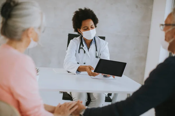 Oudere Paar Met Beschermende Gezichtsmaskers Ontvangen Nieuws Van Zwarte Vrouwelijke — Stockfoto