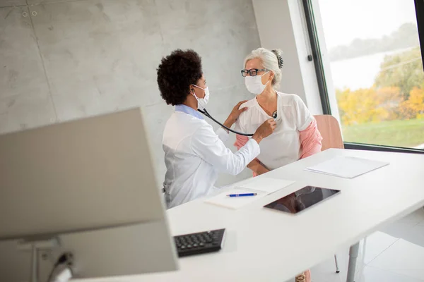 Senior Vrouw Met Beschermende Gezichtsmasker Met Een Medisch Onderzoek Door — Stockfoto