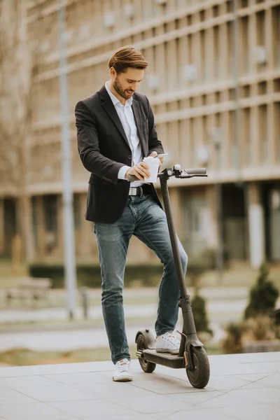 Handsome Young Businessman Using Mobile Phone While Holding Take Away — Stock Photo, Image