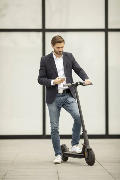 Knappe Jonge Zakenman Met Behulp Van Mobiele Telefoon Elektrische Scooter — Stockfoto