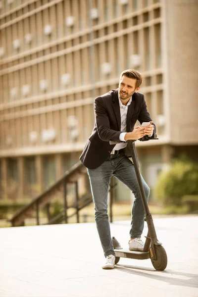 Knappe Jonge Zakenman Met Behulp Van Mobiele Telefoon Elektrische Scooter — Stockfoto