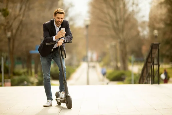 Knappe Jonge Zakenman Met Behulp Van Mobiele Telefoon Elektrische Scooter — Stockfoto