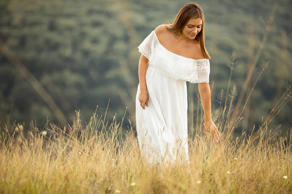 若いです妊娠中の女性で白いドレスで夏のフィールド — ストック写真