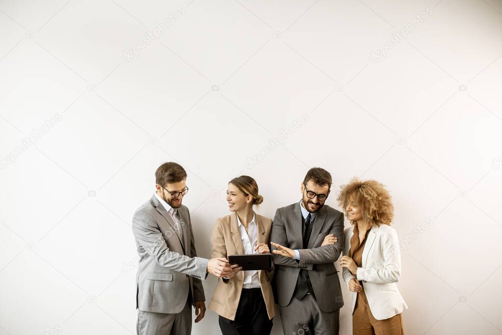 Multiethnic business people using digital tablet while standing by the wall in the modern office