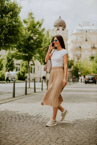 Mujer Bastante Joven Usando Teléfono Móvil Mientras Camina Por Calle — Foto de Stock