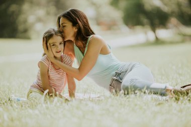 Anne ve küçük tatlı kızı parktaki çimlerde eğleniyorlar.