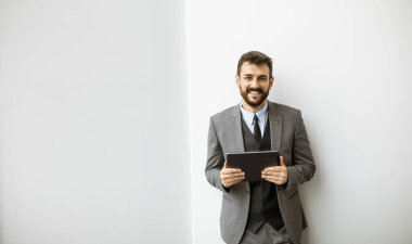 Ofiste dijital tablet kullanan yakışıklı genç iş adamı.