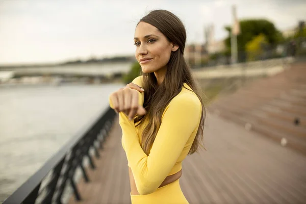 Bella Giovane Donna Che Estende Sul Lungofiume — Foto Stock