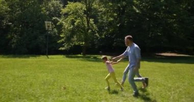 Babası ve küçük tatlı kızı parkta çimlerde eğleniyorlar.