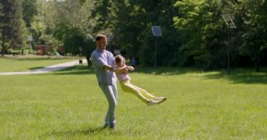 Babası ve küçük tatlı kızı parkta çimlerde eğleniyorlar.