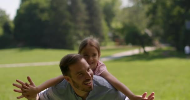 Padre con linda hija divirtiéndose en la hierba en el parque — Vídeos de Stock