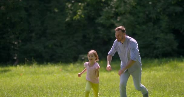 爸爸在公园玩的时候追他可爱的小女儿 — 图库视频影像