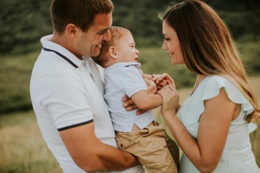Genç bir aile ve küçük tatlı bir çocuk yaz tarlasında eğleniyorlar.