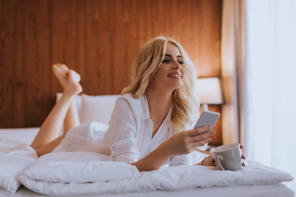 Feliz Womanl Usando Teléfono Móvil Mientras Está Acostado Cama Beber — Foto de Stock