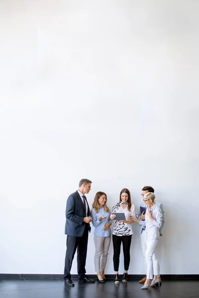 Group of business people standing by the wall in the office