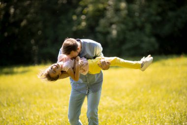 Babası ve küçük tatlı kızı parkta çimlerde eğleniyorlar.