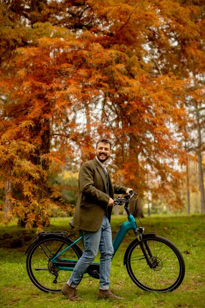 Красивый Молодой Человек Электрическим Велосипедом Помощью Мобильного Телефона Осеннем Парке — стоковое фото
