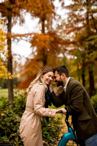 Bella Giovane Coppia Nel Parco Autunnale Con Bicicletta Elettrica — Foto Stock