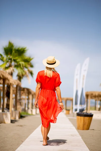 Όμορφη Νεαρή Γυναίκα Κόκκινο Φόρεμα Περπατά Μια Παραλία Καλοκαίρι — Φωτογραφία Αρχείου