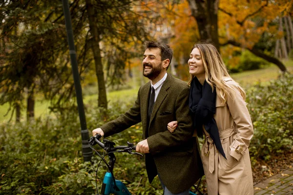 美丽的年轻夫妇在秋天的公园里骑着电动自行车 — 图库照片