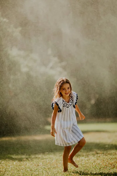 Menina Bonito Divertindo Com Água Sob Irrigação Aspersor — Fotografia de Stock