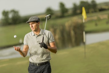 Golf oynayan genç adam.