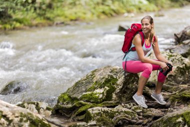 Ormanda yürüyüş yapan genç bir kadın.