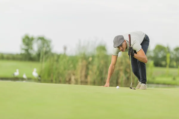 Młody człowiek gra w golfa — Zdjęcie stockowe