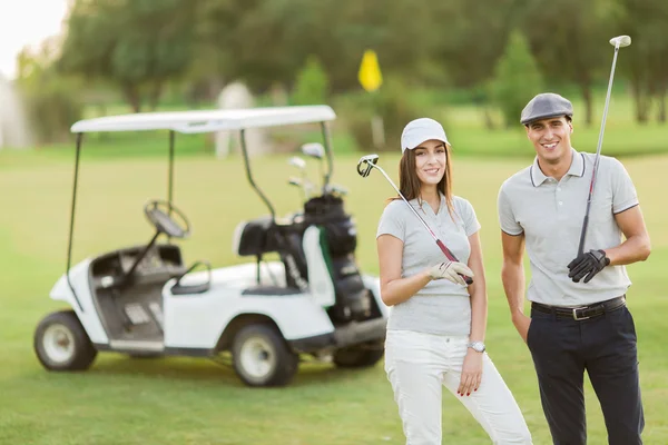 Jeune couple en voiturette de golf — Photo