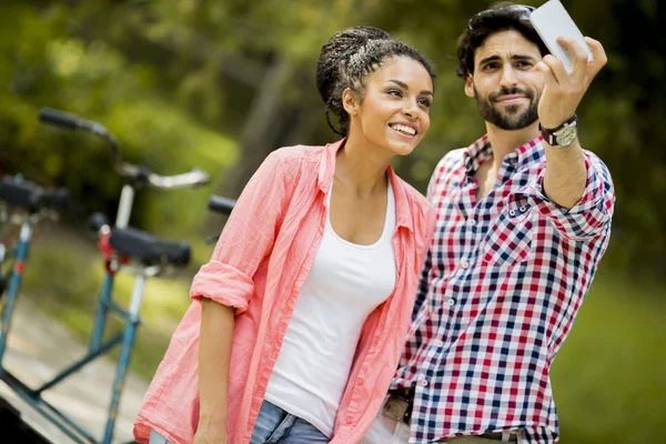 Pareja joven tomando fotos con teléfono móvil — Foto de Stock