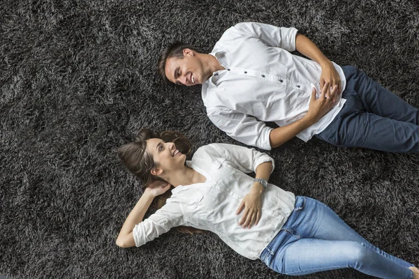 Pareja relajándose en la alfombra —  Fotos de Stock