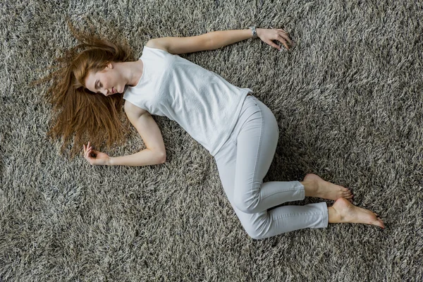 Woman lying on the carpet — Stock Photo, Image