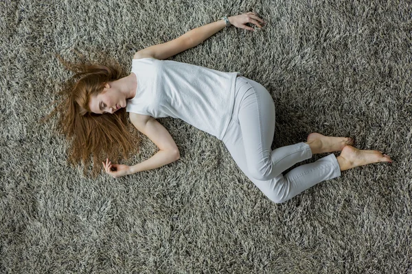 Frau liegt auf dem Teppich — Stockfoto