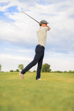 Golf oynayan genç adam.